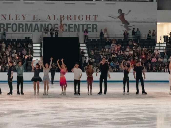 Row of skaters bowing at the end of ice show