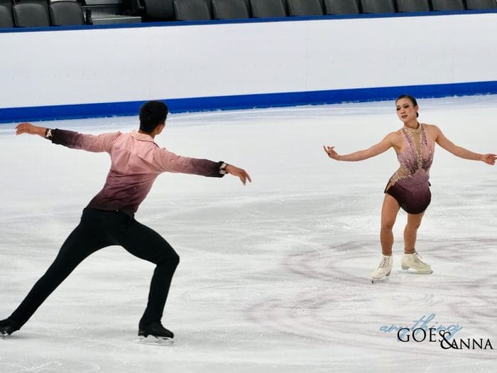 Audrey Shin and Spencer Howe circle each other on the ice, Shin faces the audience, and Spencer has his back to the camera